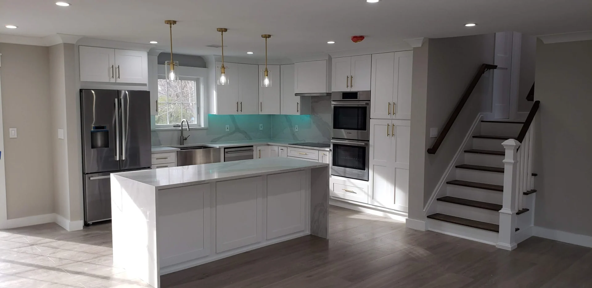 White kitchen cabinetry and wood flooring in an Innova project